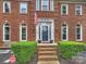 Close-up of the brick home's front entrance featuring an American flag and landscaped garden at 314 Southern Cross Ln, Matthews, NC 28105