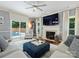 Bright living room with a fireplace, large TV, and comfortable seating, leading to the outdoor pool area at 314 Southern Cross Ln, Matthews, NC 28105