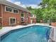 A backyard with an in-ground pool, brick home, patio and basketball hoop at 314 Southern Cross Ln, Matthews, NC 28105