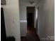 Hallway with white walls, utility closet, and tile floors leading to a bright doorway at 326 Havencrest Ct, Gastonia, NC 28052