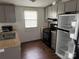 Galley kitchen with light grey cabinets, sink, stove, and refrigerator at 326 Havencrest Ct, Gastonia, NC 28052