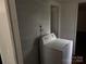 A well-lit laundry room featuring a white washing machine and wood paneled walls at 326 Havencrest Ct, Gastonia, NC 28052