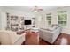 Bright living room with hardwood floors, ceiling fan, built-in bookcase, and large windows at 3326 Park South Station Blvd, Charlotte, NC 28210