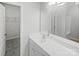 Modern bathroom featuring large mirror over vanity, tile floors, and a doorway view of the walk-in closet at 4122 Munson Dr, Charlotte, NC 28215