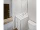 Neutral bathroom showing a sink and mirror with a white cabinet and a doorway leading outside the bathroom at 4122 Munson Dr, Charlotte, NC 28215