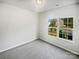 Bedroom with neutral walls, plush gray carpet and a large window overlooking the neighborhood at 4122 Munson Dr, Charlotte, NC 28215