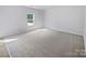 Bright bedroom with neutral carpet and a large window overlooking the backyard at 4122 Munson Dr, Charlotte, NC 28215