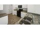 Modern kitchen boasts granite countertops, white cabinets, stainless steel appliances, and vinyl flooring at 4122 Munson Dr, Charlotte, NC 28215