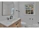 Bright bathroom featuring a wood vanity with white countertop, neutral tile, and modern fixtures at 4315 Gibbon Rd, Charlotte, NC 28269
