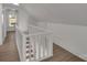 Bright, neutral hallway featuring wood floors and a white railing leading to the next level at 4315 Gibbon Rd, Charlotte, NC 28269