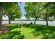 Backyard on the water featuring a firepit and chairs on the lawn, under the shade of mature trees at 4681 Dove Point Ln, York, SC 29745