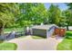 Charming gray lake house with a quaint dock, lush greenery, and inviting outdoor shower at 4681 Dove Point Ln, York, SC 29745