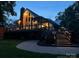 Stunning home with a brick chimney, large deck, and a beautifully landscaped yard at twilight at 4681 Dove Point Ln, York, SC 29745