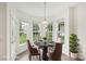 Bright breakfast nook featuring a round table, four chairs, and large windows overlooking a green landscape at 5002 Abode Lily Ln, Charlotte, NC 28227