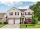 Charming two-story home featuring a brick and vinyl facade, red shutters, a well-manicured lawn and a two car garage at 5002 Abode Lily Ln, Charlotte, NC 28227