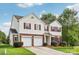 Charming two-story home featuring a brick and vinyl facade, red shutters, a well-manicured lawn and a two car garage at 5002 Abode Lily Ln, Charlotte, NC 28227
