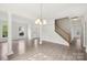 Bright living room featuring gray wood-look floors, decorative columns and staircase at 5002 Abode Lily Ln, Charlotte, NC 28227