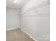 Empty walk-in closet with shelving and carpet at 5002 Abode Lily Ln, Charlotte, NC 28227