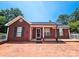 Charming brick home featuring a brick driveway, well-manicured lawn, and welcoming front porch at 501 N Johnson St, Monroe, NC 28112
