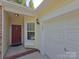 Home entrance featuring a red door, sidelight window, and attached garage at 509 Settlers Grove Ln, Salisbury, NC 28146