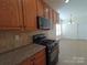 Cozy kitchen featuring light wood cabinets, granite counters, and updated appliances at 509 Settlers Grove Ln, Salisbury, NC 28146