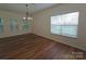 Well-lit living room with hardwood floors, large windows, and modern chandelier at 509 Settlers Grove Ln, Salisbury, NC 28146
