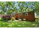 View of the backyard and brick home featuring a deck, lawn, and AC unit at 5111 Tewkesbury Rd, Charlotte, NC 28269