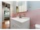 Bathroom with a sink, mirror, and cabinet with view of the bedroom through the doorway at 5111 Tewkesbury Rd, Charlotte, NC 28269
