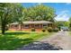 Lovely brick home with mature trees, lush lawn, and a paved driveway at 5111 Tewkesbury Rd, Charlotte, NC 28269