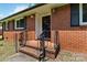 Close-up of front porch with brick steps, iron railing, and decorative front door at 5111 Tewkesbury Rd, Charlotte, NC 28269