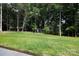 Expansive backyard featuring a lush lawn, mature trees, and a privacy at 512 Beverly Cir, Charlotte, NC 28270