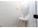 Powder room featuring a pedestal sink, round mirror, and towel ring with neutral paint at 512 Beverly Cir, Charlotte, NC 28270