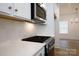 Close-up of modern kitchen features stainless steel appliances, white tile backsplash and countertop at 512 Beverly Cir, Charlotte, NC 28270