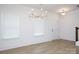 Bright living room with light wood floors, modern chandelier, and natural light from large windows at 512 Beverly Cir, Charlotte, NC 28270