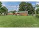 Expansive backyard displaying a lush lawn and a charming brick home exterior at 6206 Clearwater Dr, Indian Trail, NC 28079
