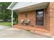 Inviting front porch with brick flooring, seating, and a charming entrance to the home at 6206 Clearwater Dr, Indian Trail, NC 28079