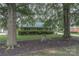 Charming brick home featuring a well-manicured lawn, mature trees, and a vintage bicycle at 6206 Clearwater Dr, Indian Trail, NC 28079