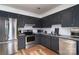 Modern kitchen with stainless steel appliances, stylish dark cabinets, and subway tile backsplash at 6206 Clearwater Dr, Indian Trail, NC 28079