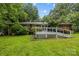 Backyard with green grass and a wooden back deck attached to the house at 6207 Robinson Church Rd, Charlotte, NC 28215