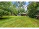 Large backyard featuring a wooden deck and plenty of mature trees for privacy at 6207 Robinson Church Rd, Charlotte, NC 28215