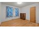 Bedroom with hardwood floors and natural light coming through a window with blue curtains at 6207 Robinson Church Rd, Charlotte, NC 28215