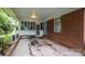 Covered carport area of a brick home featuring an outside entrance and a blue front door at 6207 Robinson Church Rd, Charlotte, NC 28215