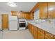 Well-lit kitchen with wooden cabinets, a white refrigerator and stove, and ample counter space at 6207 Robinson Church Rd, Charlotte, NC 28215