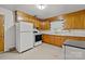 Classic kitchen featuring wooden cabinetry, white appliances, and ample counter space at 6207 Robinson Church Rd, Charlotte, NC 28215
