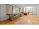 Inviting living room featuring hardwood floors, large windows with curtains, and classic sofas at 6207 Robinson Church Rd, Charlotte, NC 28215