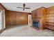 Spacious living room with wood paneling, ceiling fan, fireplace, and built in shelving at 6207 Robinson Church Rd, Charlotte, NC 28215