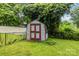 Storage shed with red doors surrounded by a black chain link fence in the backyard at 6207 Robinson Church Rd, Charlotte, NC 28215
