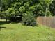 Spacious backyard with lush greenery, a wooden fence, and covered carport at 714 E Dunlap St, Lancaster, SC 29720