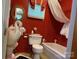 Red bathroom features a swan sink, toilet, and tub at 714 E Dunlap St, Lancaster, SC 29720