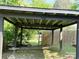 View of the wooden carport surrounded by lush greenery and a fenced in backyard at 714 E Dunlap St, Lancaster, SC 29720